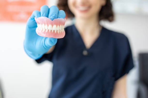 Dentist holding denture